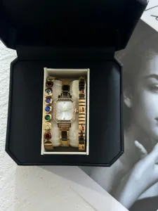 Nahaufnahme einer goldenen rechteckigen Uhr mit bunten Edelstein- und Kirscharmbändern