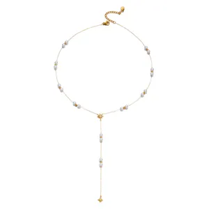 Detail view of delicate gold Y-shaped necklace with white pearls and eight-pointed stars
