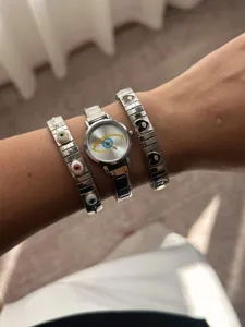 Detailed shot of vintage evil eye watch set with heart charm bracelets on wrist