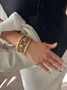 Detail of a gold hexagonal watch with black dial and matching diamond bracelets