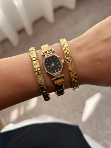 Detailed view of a gold-tone octagonal watch with matching crystal-set bracelets
