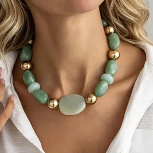 Vue détaillée d'un collier de perles vert menthe irrégulières et de billes dorées.