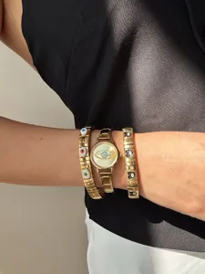 Detail view of vintage gold evil eye watch and matching heart stretch bracelet set