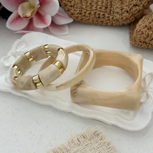 Close-up view of vintage marbled acrylic bracelet set on a decorative white tray
