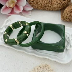 Detail of vintage green marbled acrylic bracelet set with square and beaded styles.