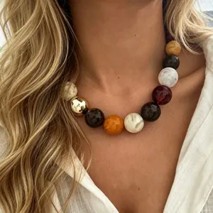 Gros plan d'un collier à grosses perles multicolores de style bohème porté