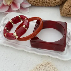 Detailed view of vintage marbled red acrylic bangle set featuring round and square shapes