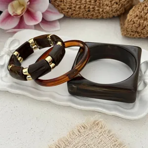 Macro view showing the marbled texture and gold spacers of vintage acrylic bracelet set