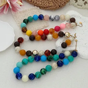 Vue détaillée de grandes perles en résine multicolores sur des colliers style bohème