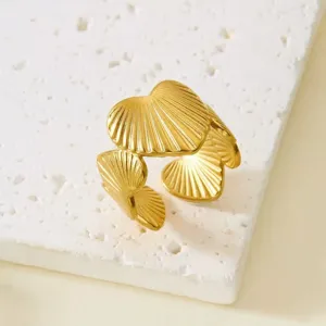 Nahaufnahme der Textur eines vergoldeten, muschelförmigen, verstellbaren Rings aus Edelstahl