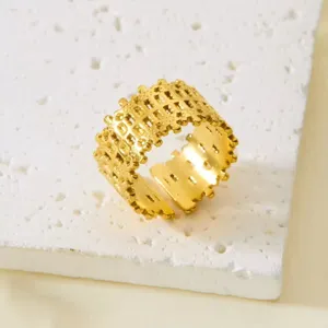 Detailansicht eines vergoldeten Edelstahlrings mit unregelmäßiger geometrischer Textur.