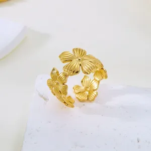 Detailaufnahme eines vergoldeten Edelstahlrings mit eleganten Blumenmotiven auf Stein.