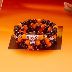 Detailansicht von Halloween-Perlenarmbändern mit orange-schwarzen Perlen und Geister-Anhängern