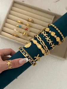 Exklusive goldene Edelstahl Armbänder mit Seestern und Muschel Motiven im Ozean Stil