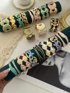 Detailansicht der Emaille-Armreifen im Meeres-Design mit Seestern und Goldschleife.