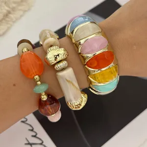 Close-up van kleurrijke macaron stenen armbandenset met gouden armband en kralen