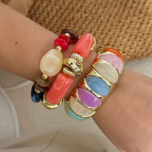 Detailopname van kleurrijke stenen kralenarmband en gouden hars armband