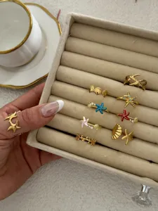 Goldene Seestern- und Muschelringe in einer Samtschmuckschatulle für den Strandlook