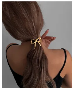Detailansicht eines eleganten goldenen Schleifen-Haaraccessoires am Modellhaar