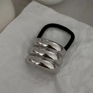 Detaillierte Ansicht der minimalistischen dreifachen silbernen Metall-Haarmanschette.