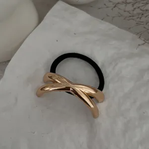 Detaillierte Ansicht eines minimalistischen goldenen Haargummis auf weißer Fläche