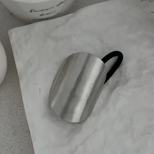 Detail einer minimalistischen silbernen Haarmanschette mit schwarzem Gummiband auf Textur