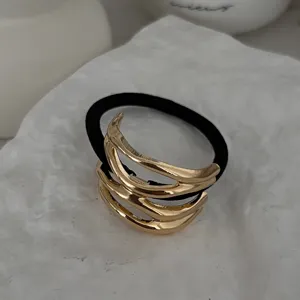 Detailaufnahme eines minimalistischen goldenen Metall-Haargummis mit elastischem Band.
