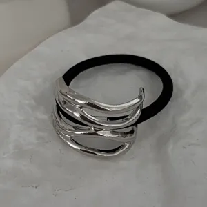 Detailansicht eines minimalistischen silbernen Haargummis aus unregelmäßiger Legierung