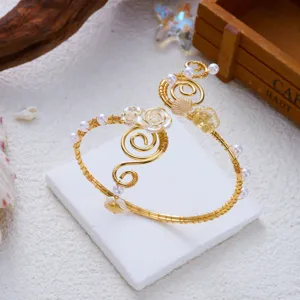 Vista dettagliata del bracciale da braccio dorato con conchiglie e perle