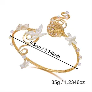 Vista dettagliata di un bracciale a tema oceano con motivi di conchiglie e farfalle in oro.
