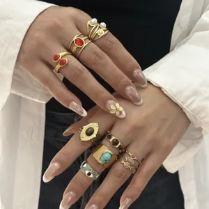 Dettaglio di anelli vintage in oro con turchese e pietre preziose colorate sulla mano