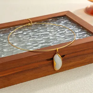 Close-up of a gold-plated choker necklace with an irregular white stone pendant