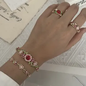 Vintage enamel flower bracelet and ring set worn on hand showing intricate vine details
