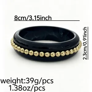Vista dettagliata del bracciale vintage in smalto nero con inserti di perline dorate.