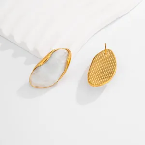 Detailed view of minimalist gold irregular wavy earrings featuring white marble texture inlay