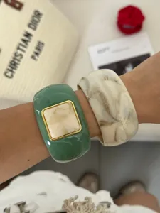 Close-up of vintage resin bangles with marble texture and square inlay details