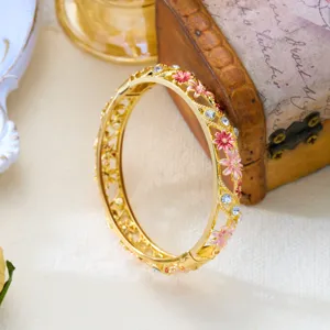 Close-up of retro enamel floral bangle with hollow vine and sparkling crystals.