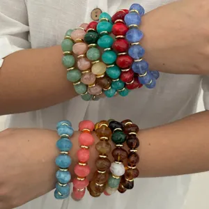 Detailansicht bunter unregelmäßiger Steinperlenarmbänder mit eleganten Goldperlen