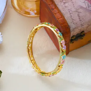 Close-up of vintage gold enamel flower bangle with intricate hollow vine flower details