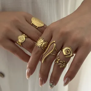 Primo piano di anelli d'oro vintage regolabili con incisioni simboliche uniche