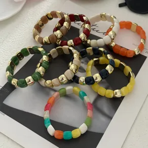 Nahaufnahme bunter Harzperlenarmbänder mit Vintage-Gold-Zierelementen auf Magazin