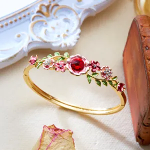 Detailed view of vintage enamel floral bangle featuring hollow vine and red crystal