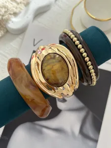 Primo piano di bracciali vintage in smalto e con perline su supporto verde