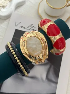 Primo piano di bracciali vintage in smalto con dettagli dorati su supporto di velluto