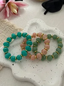 Detailansicht von drei bunten Armbändern aus Kunstjade mit goldenen Trennelementen