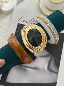 Dettaglio di set di bracciali vintage su supporto per gioielli in velluto verde
