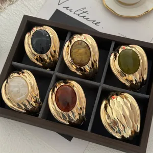 Dettaglio di bracciali vintage in oro con pietre colorate in una scatola da esposizione