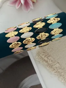 Detailansicht farbenfroher Emaille-Armreifen mit goldfarbener Hammerschlag-Textur