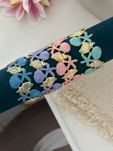 Detaillierte Ansicht bunter Emaille-Armreifen mit Seestern- und Muschelmuster für den Urlaub