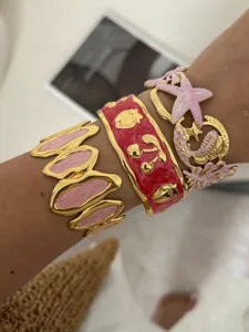 Detailopname van kleurrijke emaille armbanden met kersen-, aardbeien- en zeester-motieven